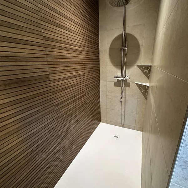 Douche avec mur effet bois latté 3D et carrelage effet pierre claire