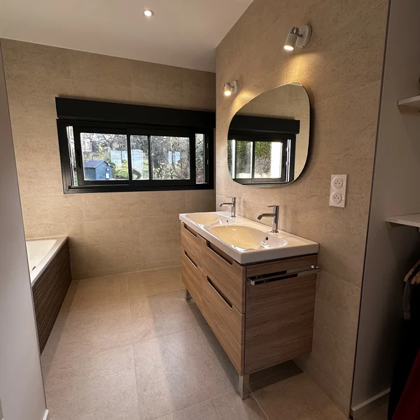 Salle de bain beige avec double vasque et baignoire carrelée